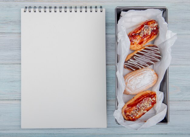 Hoogste mening van cakes en blocnote op houten achtergrond met exemplaarruimte