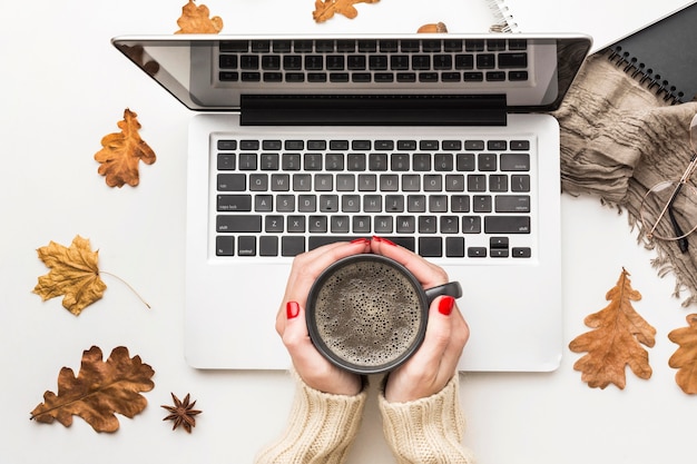 Hoogste mening van de koffiekop van de persoonsholding met laptop