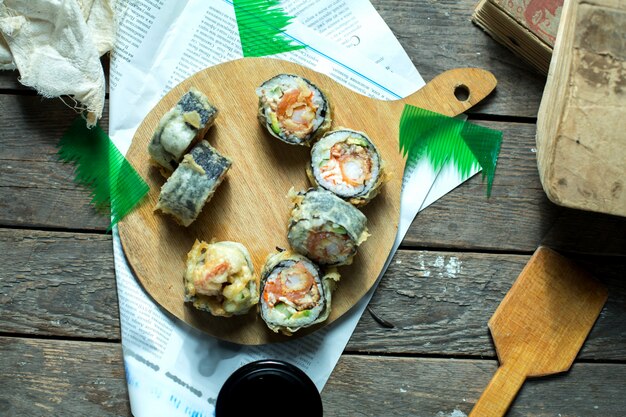 Hoogste mening van Japanse traditionele de sushimaki van voedseltempura die met gember en sojasaus op een houten raad wordt gediend