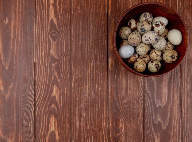 Hoogste mening van kwartelseieren met roomkleurige shells met bruine vlekken op een houten achtergrond met exemplaarruimte