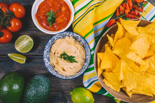 Hoogste mening van Mexicaanse nachosspaanders; avocado; salsa saus; Cherry-tomaten; rode pepers en citroen op tafel