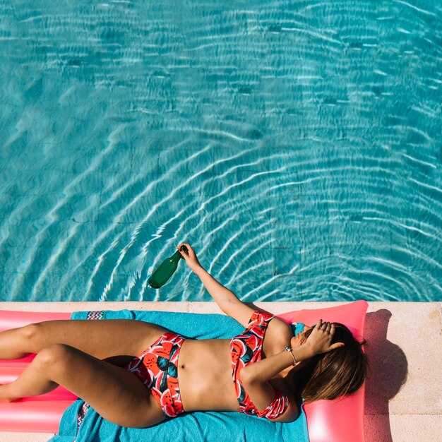 Hoogste mening van vrouw het ontspannen naast pool