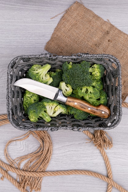 Gratis foto hoogste meningsbroccoli en mes in mand dichtbij de jute en het touw