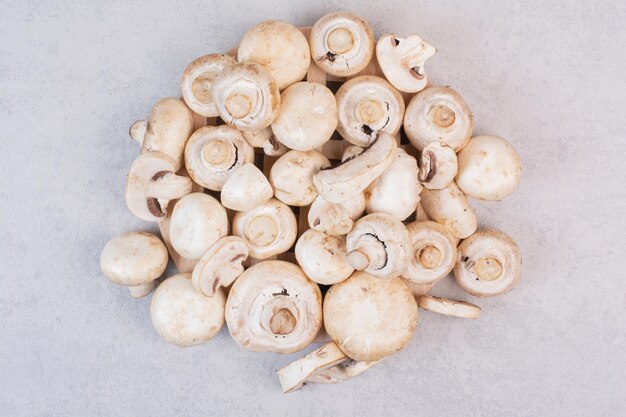 Hoop rijpe paddestoelen op marmeren tafel.