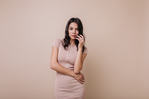 Horizontaal portret van charmante vrouw met paarse manicure. Het mooie tan model stellen