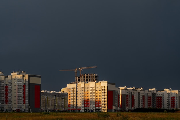 Horizontaal schot van gebouwen op de bouwplaats onder een bewolkte hemel bij zonsondergang