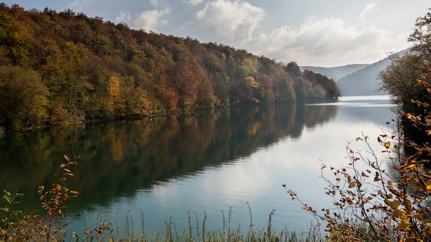 Horizontaal schot van mooi Plitvice-meer in het meer van Kroatië dat door kleurrijk-doorbladerde bomen wordt omringd