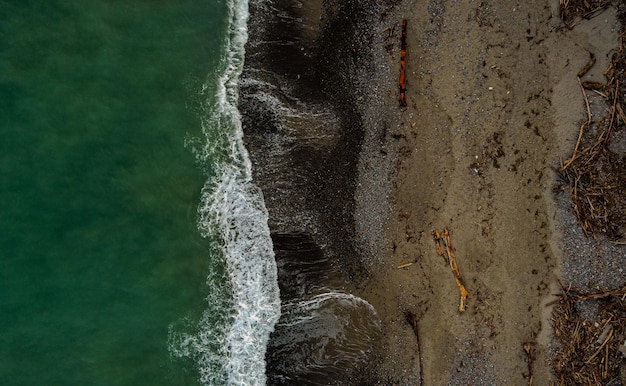 Horizontale luchtfoto van een schuimige oceaan die de kliffen raakt