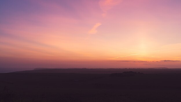 Horizontale opname van een veld onder de adembenemende paarse lucht