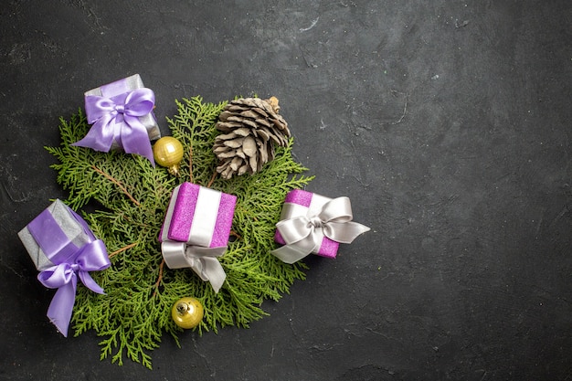 Horizontale weergave van kleurrijke nieuwjaarsgeschenken decoratie accessoire en conifer kegel op donkere achtergrond