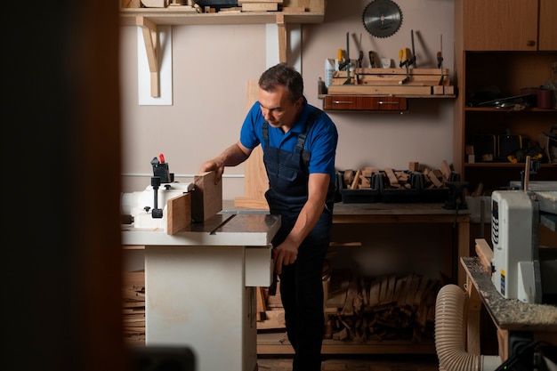 Houtbewerker in zijn winkel die werkt met gereedschappen en apparatuur