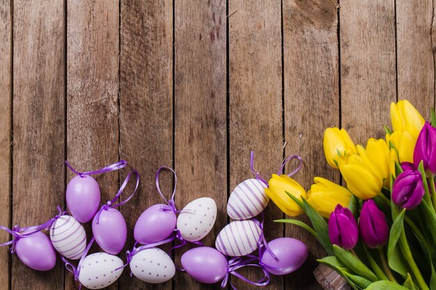 Houten achtergrond met bloemen en paaseieren