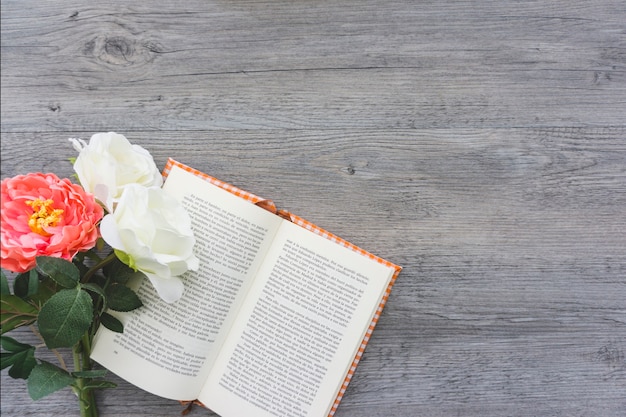 Houten achtergrond met bloemen op een open boek