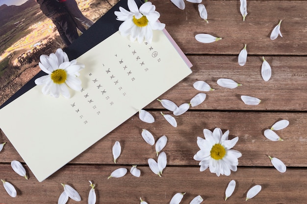 Houten achtergrond met kalender en bloemen