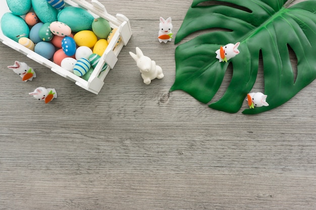 Gratis foto houten achtergrond met pasen eieren en schattige konijnen