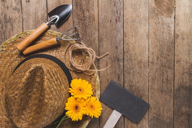 Houten achtergrond met tuingereedschap en gele bloemen