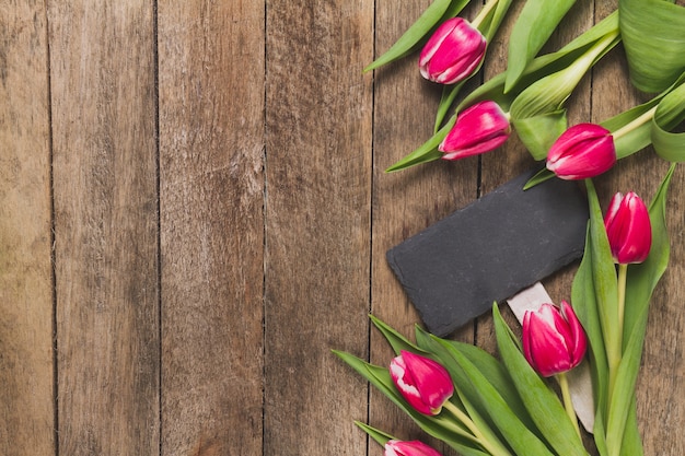 Houten achtergrond met tulpen en teken