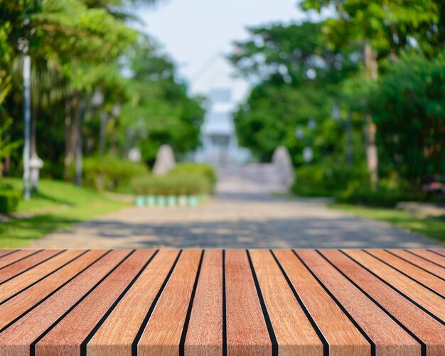 Houten bord lege tafel voor wazige achtergrond. Perspectief bruin hout met wazige mensen activiteiten in het park - kan worden gebruikt voor het weergeven of montage van uw producten. lente seizoen. vintage gefilterd beeld.