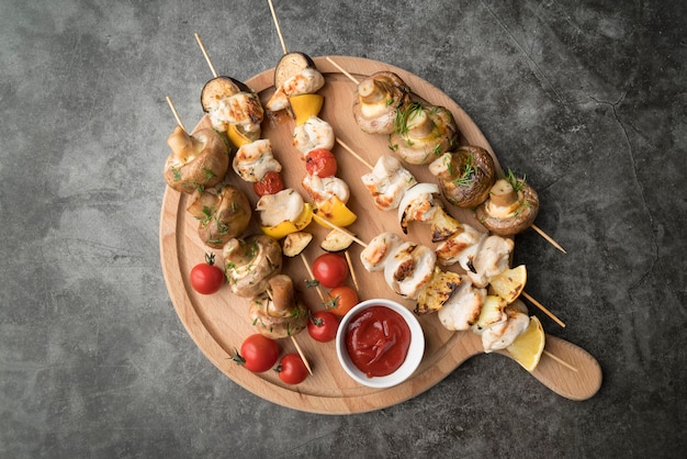 Houten bord met gegrilde kip en groenten spiesjes