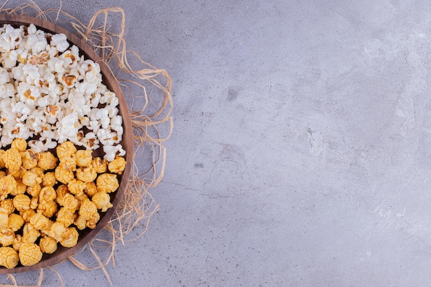 Houten dienblad met assortiment popcorn geplaatst op stapel stro op marmeren achtergrond. Hoge kwaliteit foto