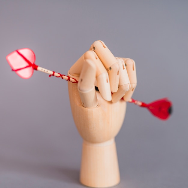 Gratis foto houten hand met liefde pijl op grijze tafel