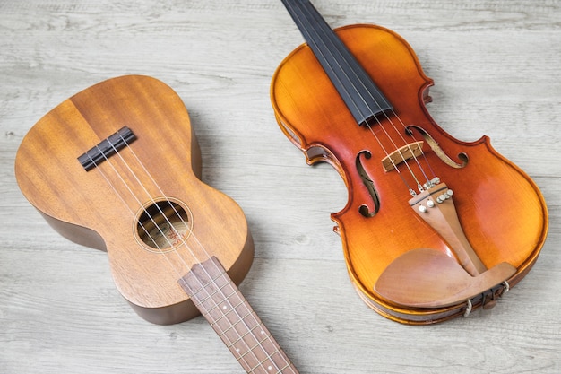 Houten klassieke gitaar en viool op gestructureerde achtergrond