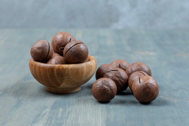 Houten kom met chocoladeballen die op houten oppervlak worden geplaatst.