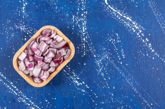 Gratis foto houten kom met gesneden paarse uien op marmeren oppervlak