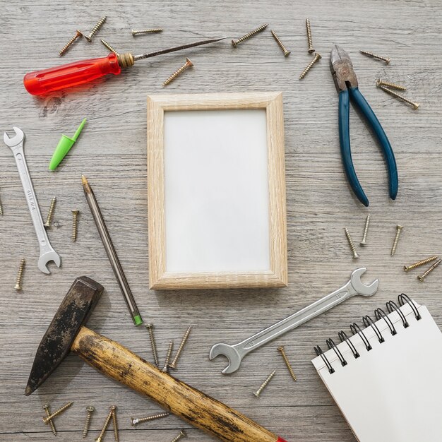 Houten oppervlak met frame, notitieboekje en gereedschap