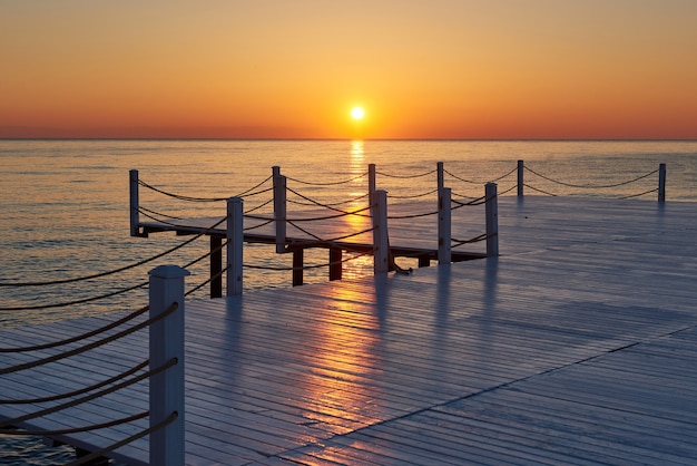 Houten pier op een mooie oranje zonsondergang.