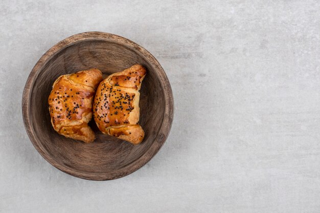 Houten plaat van vers lekker gebak op stenen tafel.