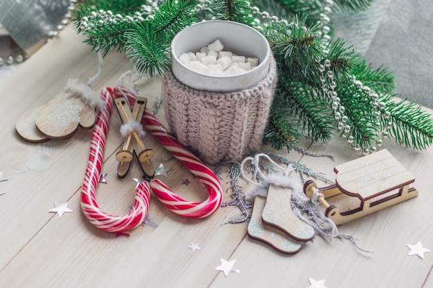 Houten tafel bedekt met snoepgoed, marshmallows en kerstversieringen onder de lichten