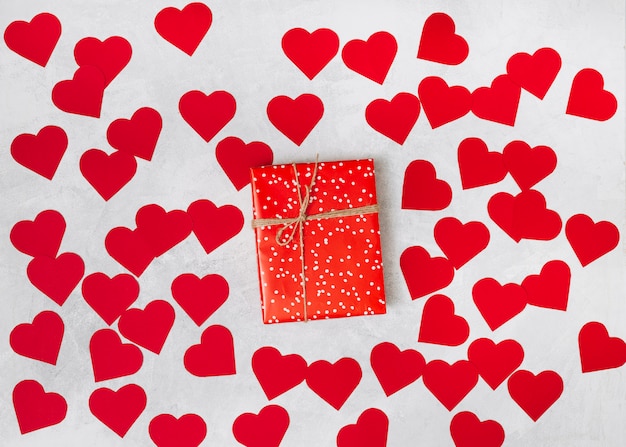 Gratis foto huidige doos tussen een hoop papieren decoratieve harten