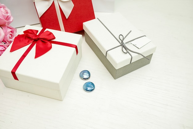 Huidige geschenkdoos en lint op witte houten tafel
