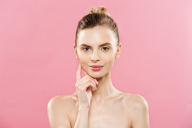 Huidverzorgingsconcept - Charmante jonge blanke vrouw met perfecte make-up foto samenstelling van brunette meisje. Geïsoleerd op roze achtergrond met kopie ruimte.