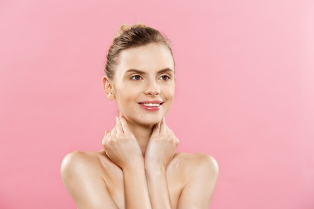 Huidverzorgingsconcept - Charmante jonge blanke vrouw met perfecte make-up foto samenstelling van brunette meisje. Geïsoleerd op roze achtergrond met kopie ruimte.