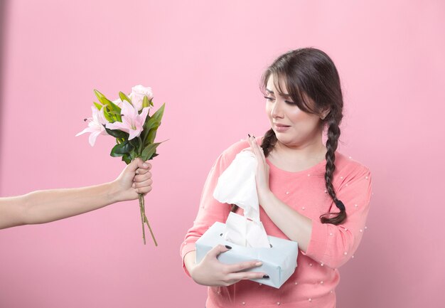 Huilende vrouw die lelieboeket verwerpen terwijl het houden van servetten