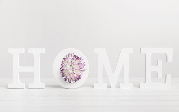 Huis geschreven met witte letters en mooie bloem
