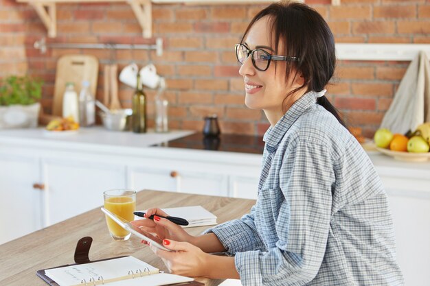 Huiselijke sfeer, technologie en levensstijlconcept. Mooie jonge vrouw doet online winkelen