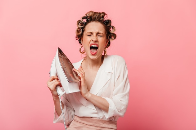 Huisvrouw in witte blouse schreeuwt van de pijn, heet ijzer aanraken