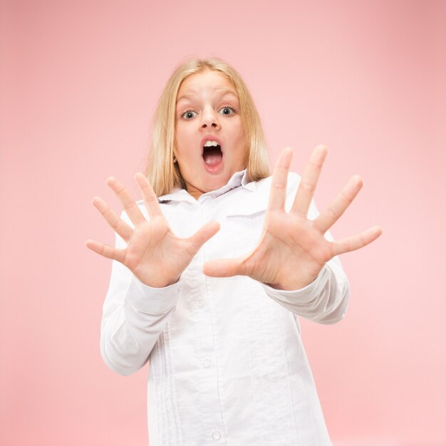 Ik ben bang. Schrik. Portret van het bang gemaakte tienermeisje. Ze stond geïsoleerd op trendy roze studio achtergrond. Vrouwelijk portret van halve lengte. Menselijke emoties, gezichtsuitdrukking concept. Vooraanzicht