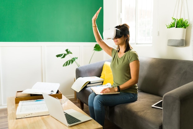 Gratis foto ik heb een vraag. slimme halfvolwassen studente die haar hand opsteekt om haar mening te geven aan een universitair docent over haar virtual reality-les