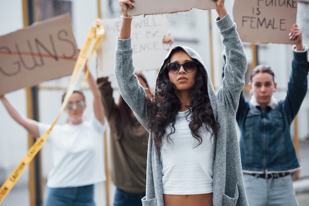 Gratis foto in zonnebril en capuchon. een groep feministische vrouwen protesteert buitenshuis voor hun rechten