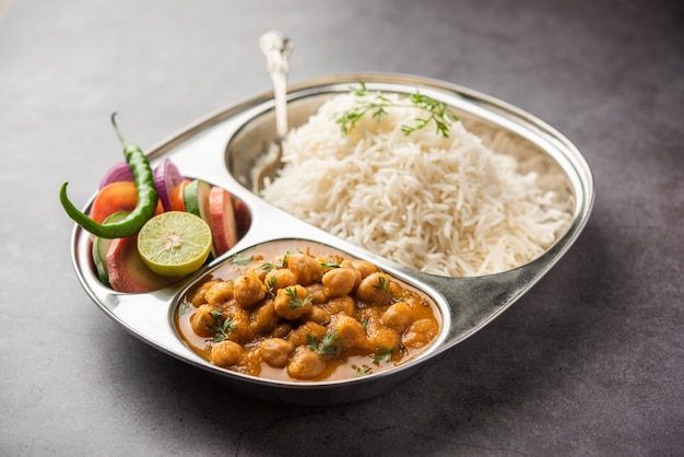 Indiaas eten chole chawal of pittige kikkererwtencurry met gewone rijst geserveerd met groene salade. selectieve focus
