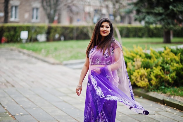 Indiaas hindoe-meisje bij traditionele violette sari poseerde op herfststraat