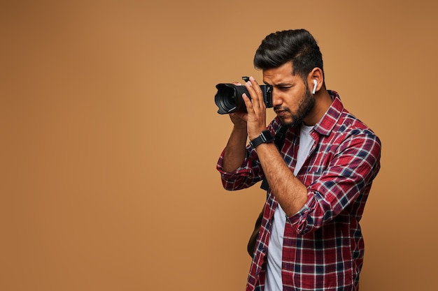 Indiase fotograaf met camera op pastelmuur