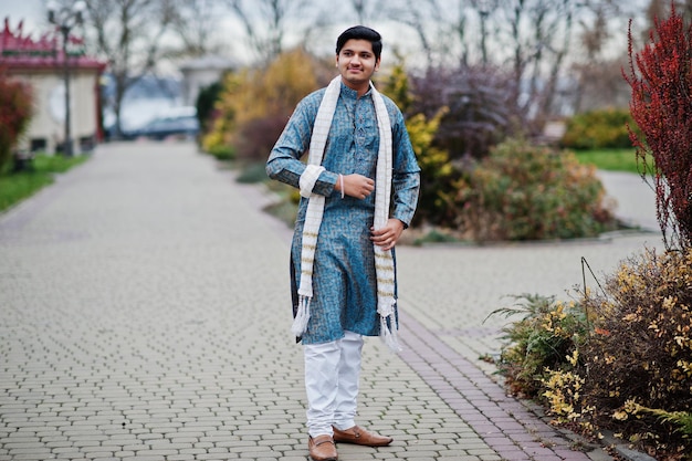 Indiase man draagt traditionele kleding met witte sjaal buiten geposeerd