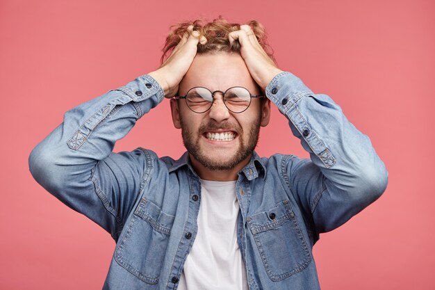 Indoor portret van bebaarde jonge man met trendy kapsel