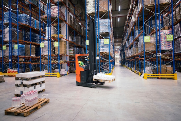 Industrieel gebouw groot magazijn interieur met heftruck en palet met goederen en planken