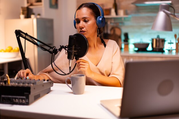 Influencer die een koptelefoon draagt en nieuwe podcastseries opneemt voor haar publiek. On-air online productie internetuitzending show host streaming live inhoud, opname van digitale sociale media-communicatie